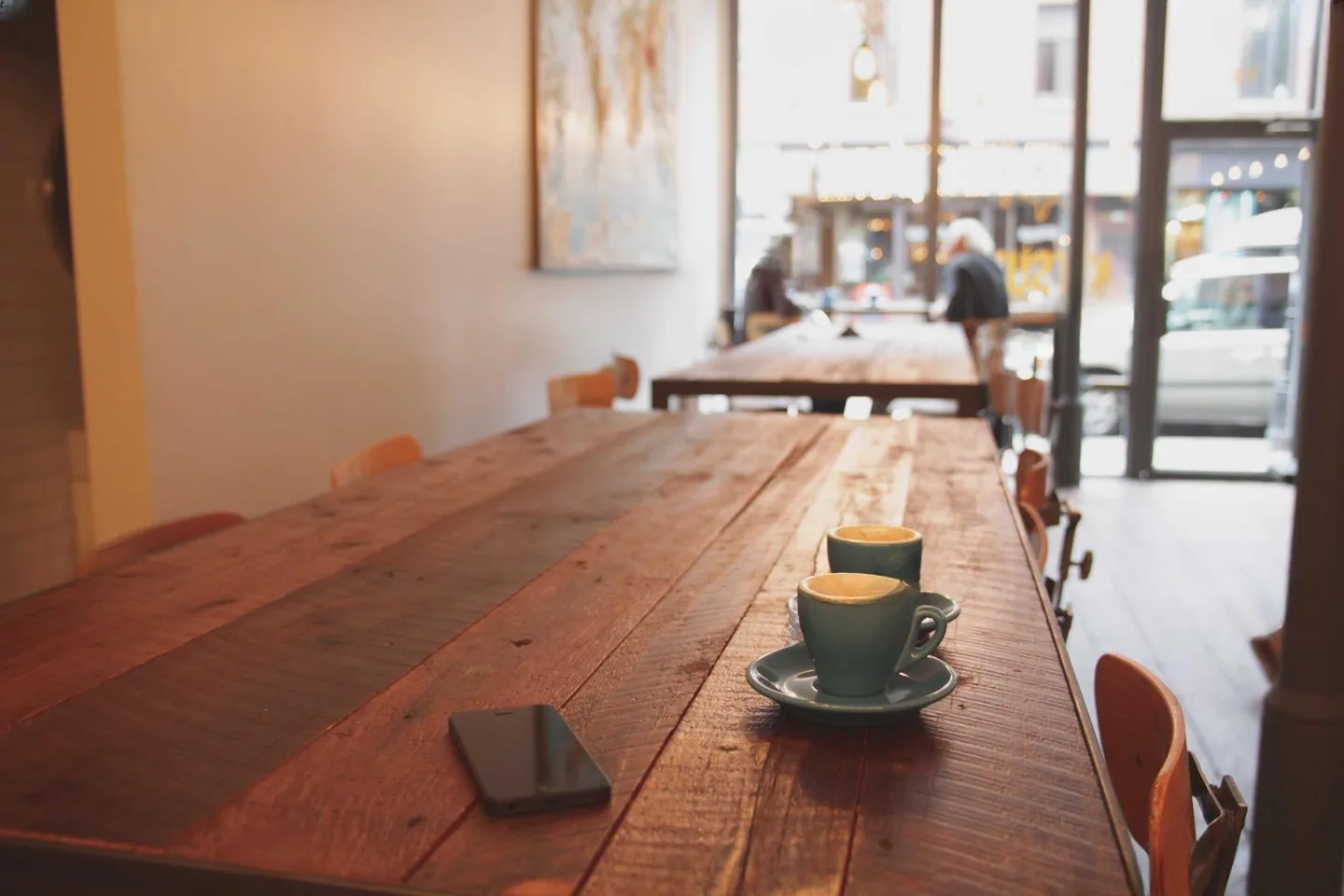 The same cafe photograph with the watermark grid removed, wood grain and window light intact