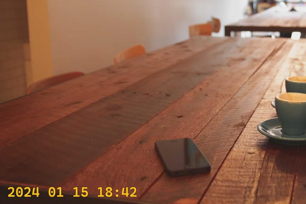 Close crop of a wooden table with a yellow camera date stamp burned in